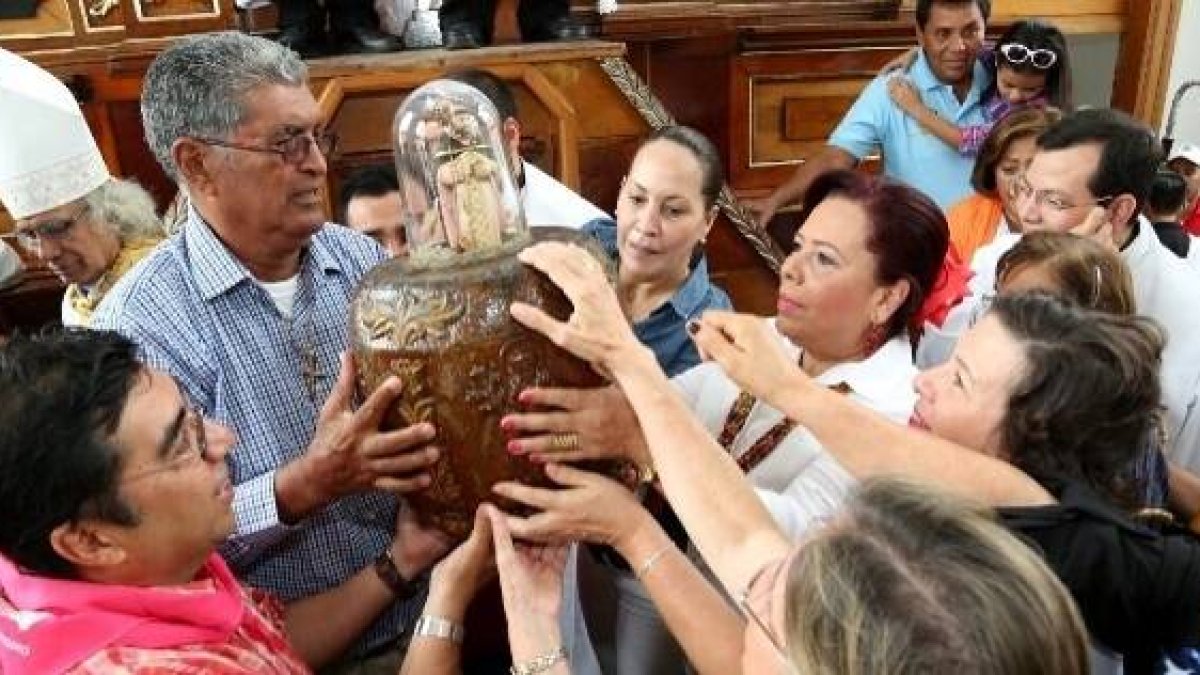 Una imagen del cardenal Brenes, con mitra episcopal, y devotos con la imagen de Santo Domingo, en años anteriores al coronavirus