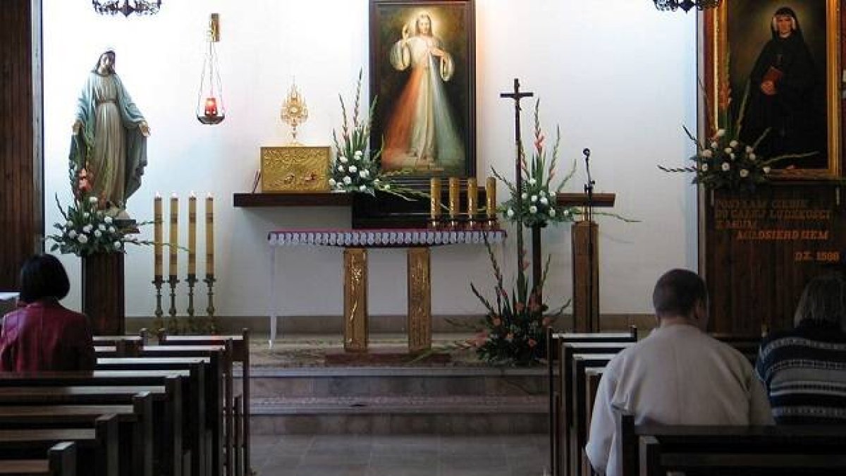 Oración ante el icono de la Divina Misericordia y un retrato de Santa Faustina Kowalska