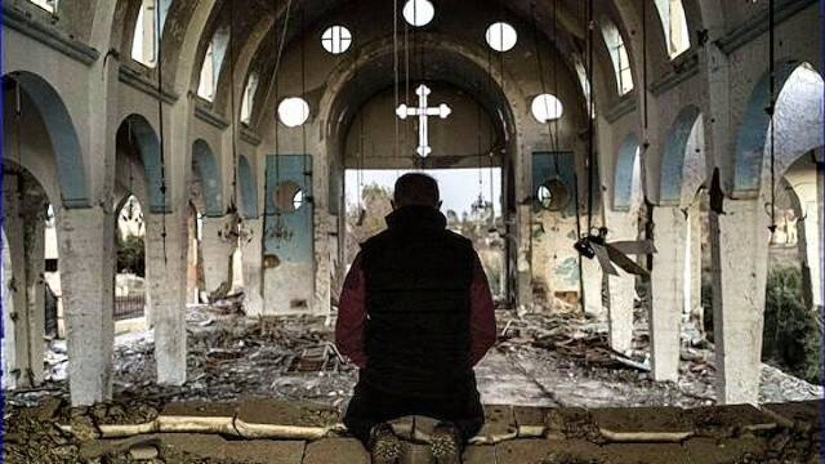 Oración en un templo católico en Siria totalmente destruido. Foto: Asia News.