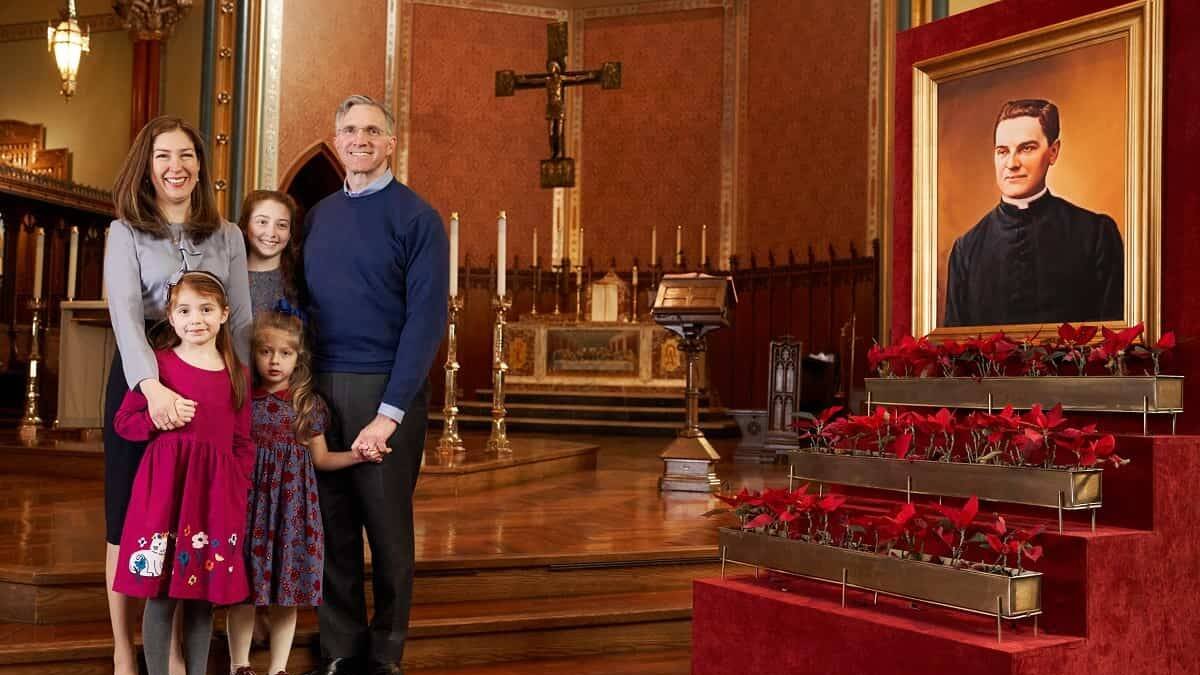 Patrick Kelly, con su mujer y sus tres hijas junto a una imagen del padre Michael J. McGivney, fundador de los Caballeros de Colón