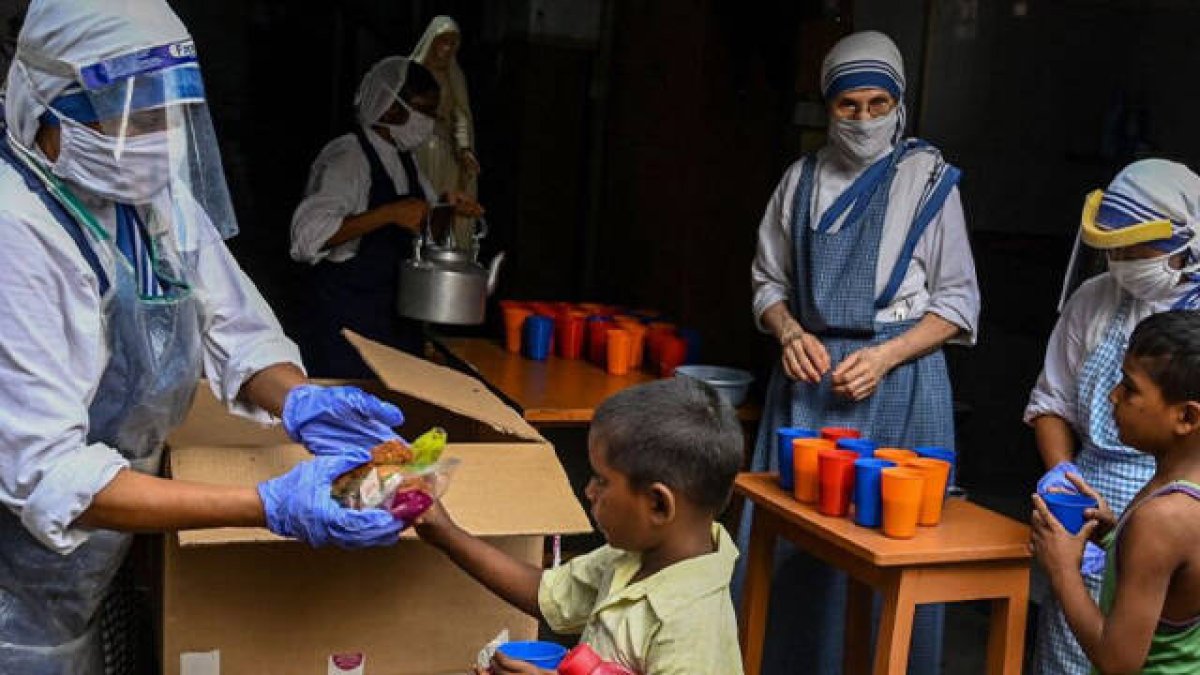 Una Misionera de la Caridad entregando comida a un niño en la India
