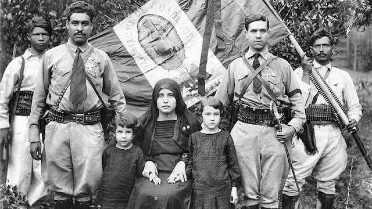 Familia cristera junto a la bandera mexicana y guadalupana, prestos al combate por Cristo Rey.