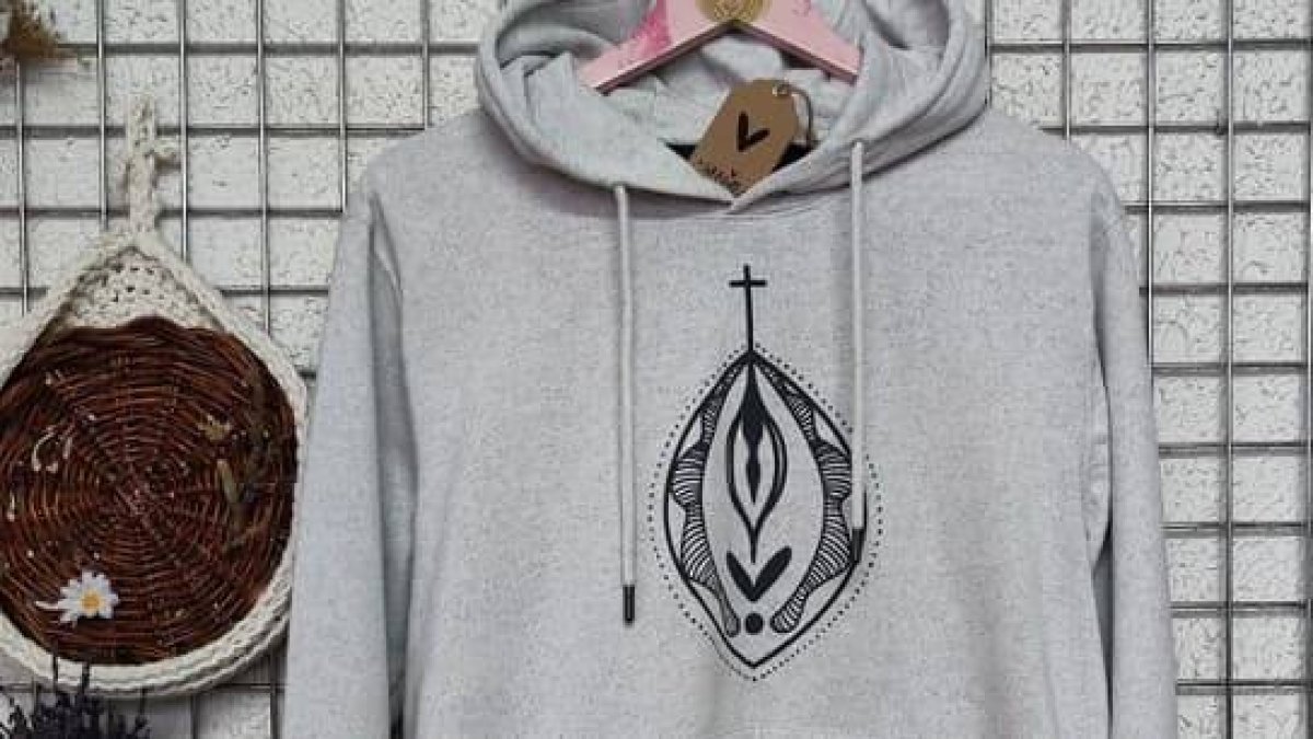 Sudadera pintada por la organizadora del taller con una vulva coronada por una cruz