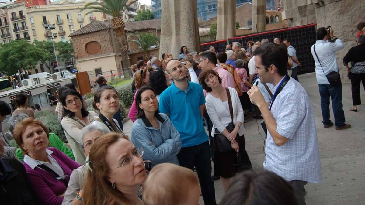 Un voluntario de Nártex aparece en la imagen explicando la basílica de la Sagrada Familia desde una perspectiva cristiana / Nártex