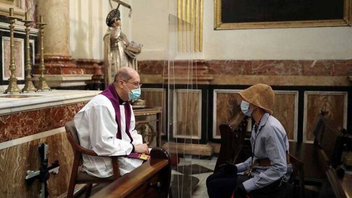 Confesión con precauciones por coronavirus en la catedral de Valencia, España