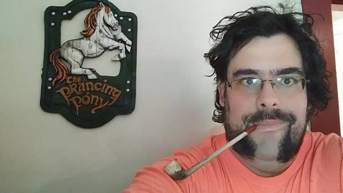 James Spahn en la cocina de su casa, con su pipa y el cartel de El Poney Pisador, la taberna de El Señor de los Anillos
