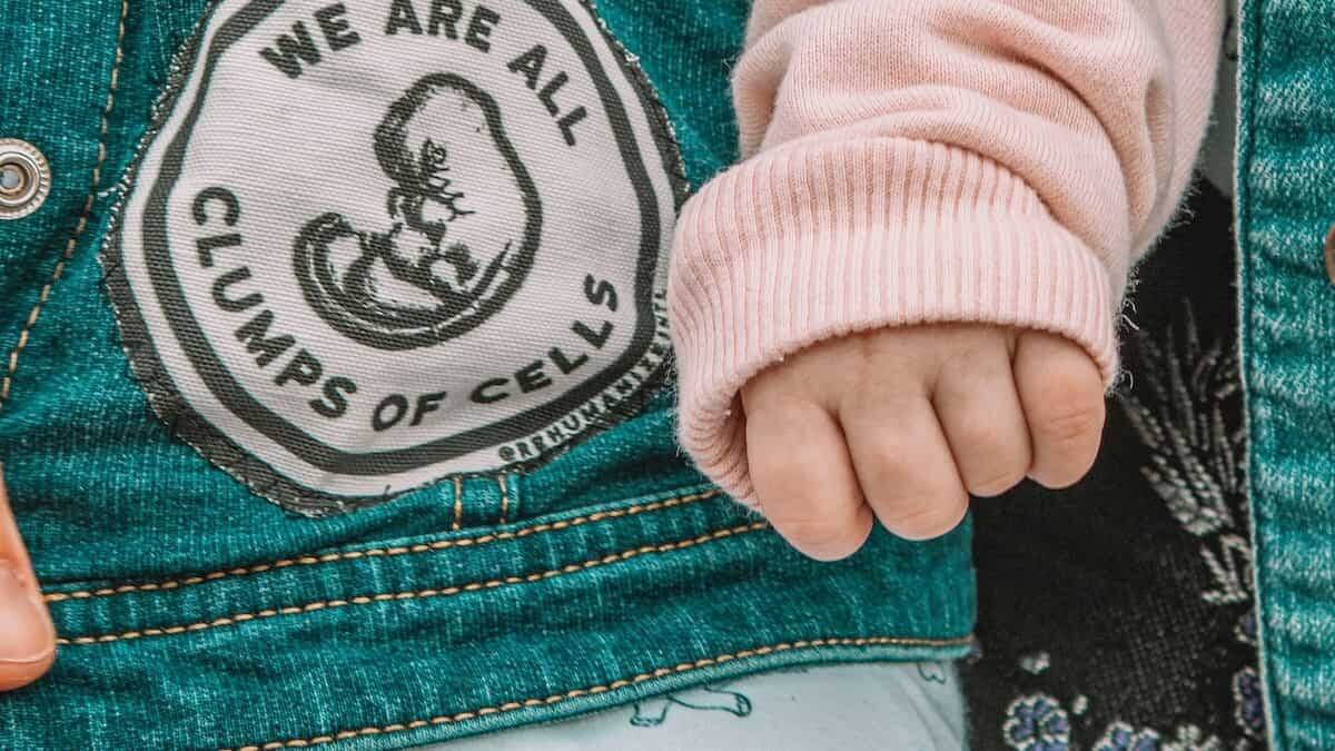 'El embrión solo es un conjunto de células', dice la propaganda abortista. 'Todos somos un conjunto de células', responde la etiqueta en la ropa de este bebé en una manifestación provida. Foto: Maria Oswalt / Unsplash.