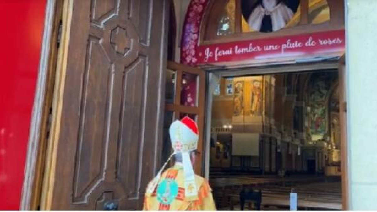 El obispo de Lisieux en la puerta del Jubileo, con la promesa de Teresita de enviar una lluvia de rosas, símbolo de favores