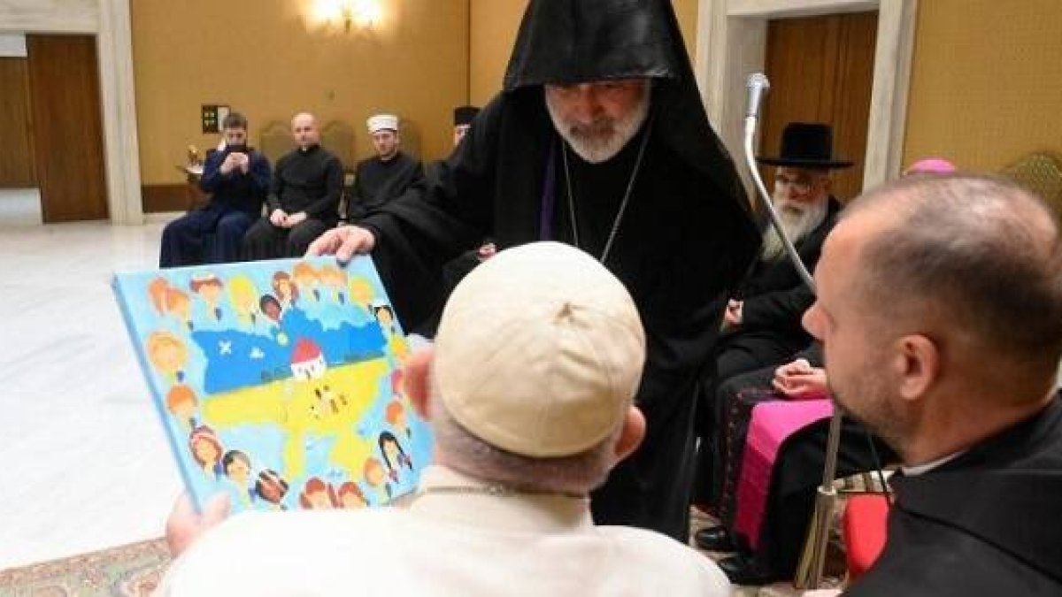 Un delegado ortodoxo de Ucrania entrega un dibujo infantil con el mapa del país al Papa Francisco en su reunión interreligiosa
