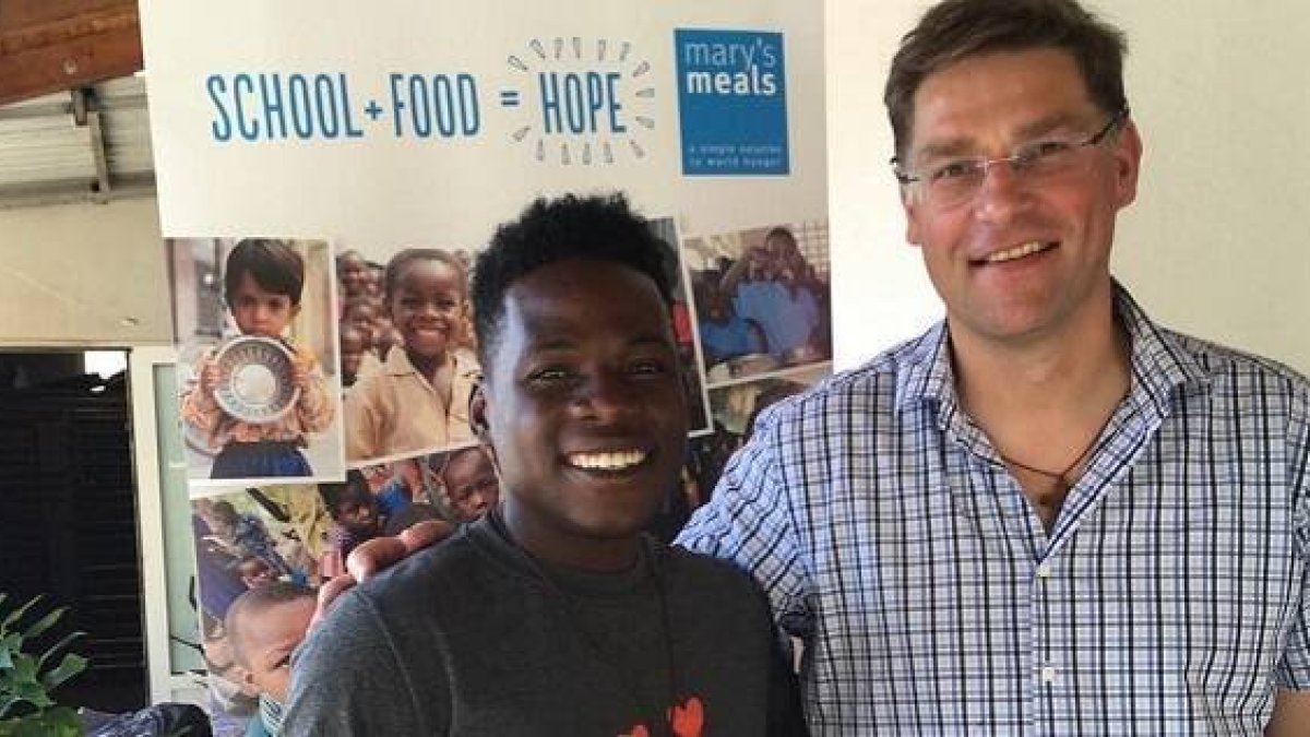 Magnus, fundador de Mary's Meals, con un joven haitiano, antiguo beneficiado, hoy colaborador.