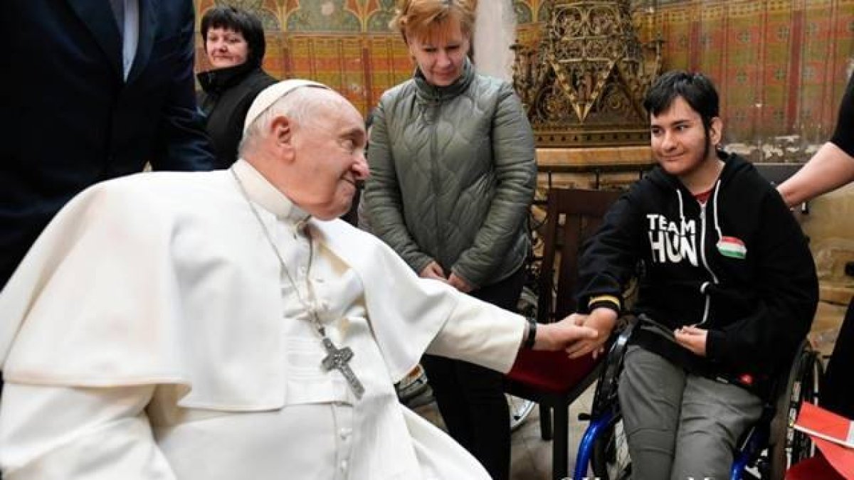Francisco saluda a uno de los asistentes al acto en la iglesia de Santa Isabel de Hungría. Foto: Vatican Media.