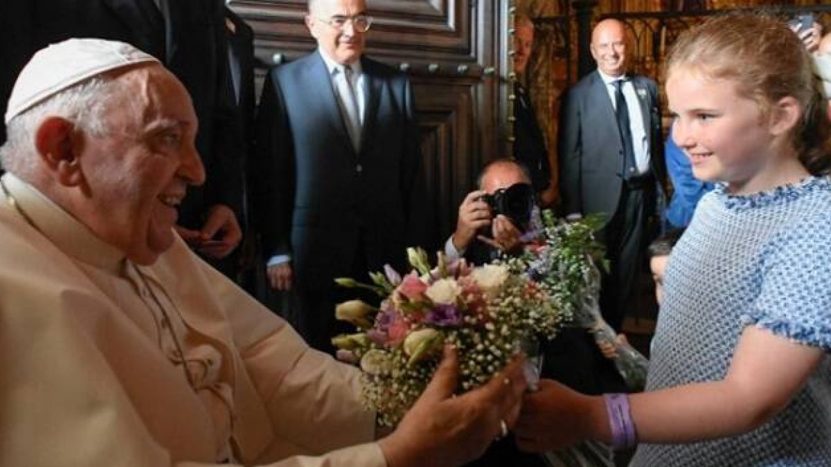Una niña entrega flores al Papa en los Jerónimos de Lisboa antes de las vísperas
