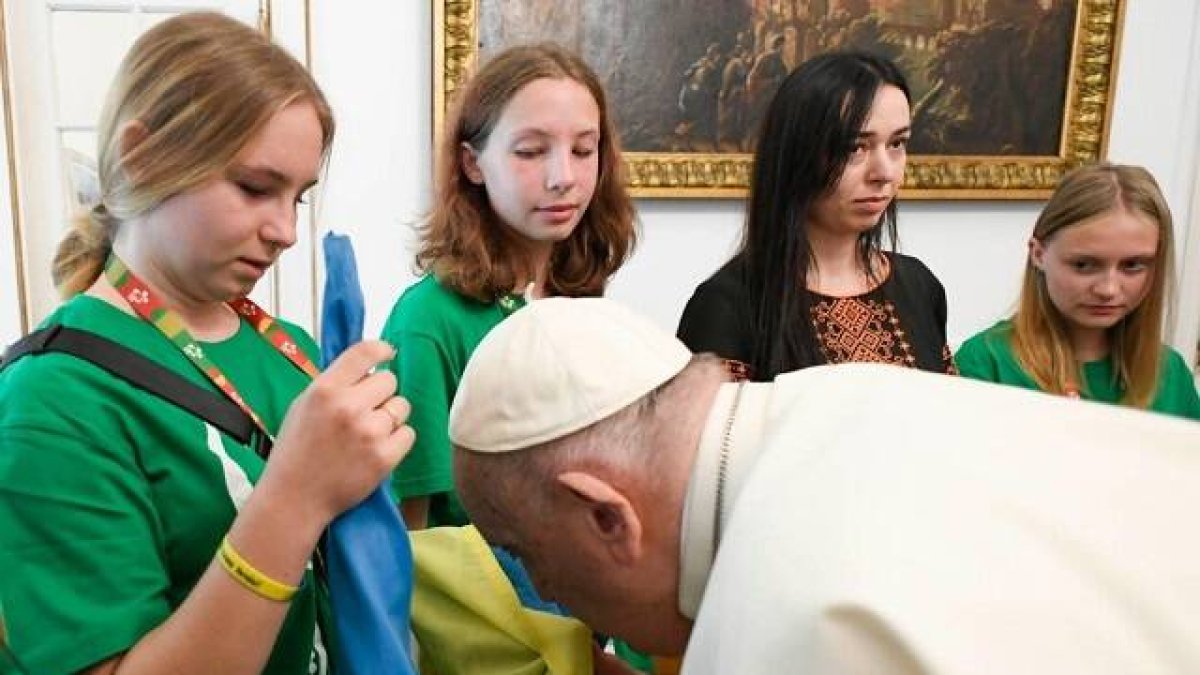 Francisco besa una bandera ucraniana al recibir 15 peregrinos ucranianos en la Nunciatura de Lisboa