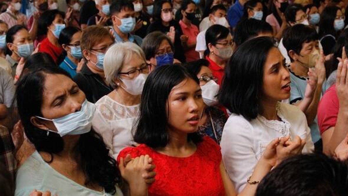Filipinos en misa rezan con las manos levantadas el Padrenuestro