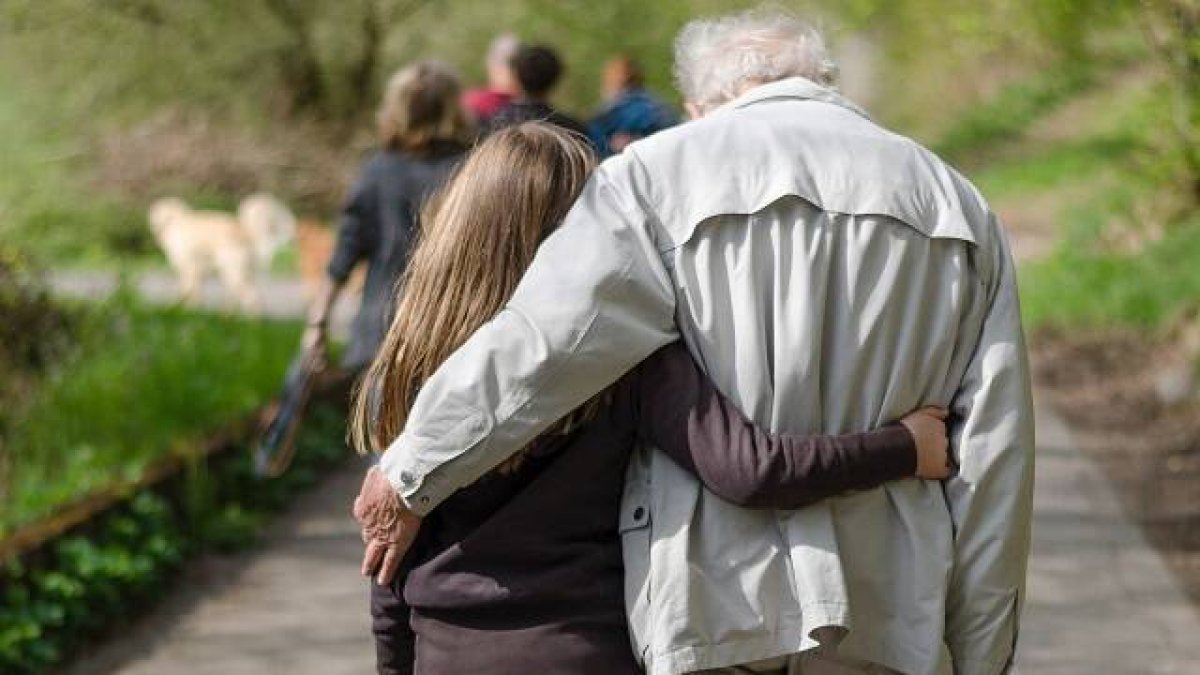 Un anciano y una muchacha, caminan unidos; foto de Janosch Lino para Unsplash