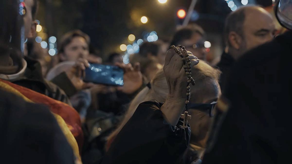 En la imagen, una mujer sostiene el Rosario durante las concentraciones ante la sede socialista de la calle Ferraz de Madrid.