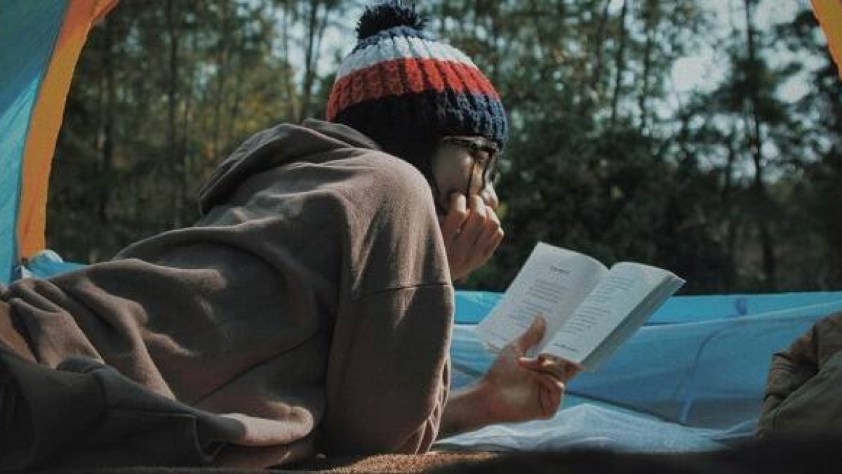 Una joven o adolescente absorta en la lectura en pleno invierno