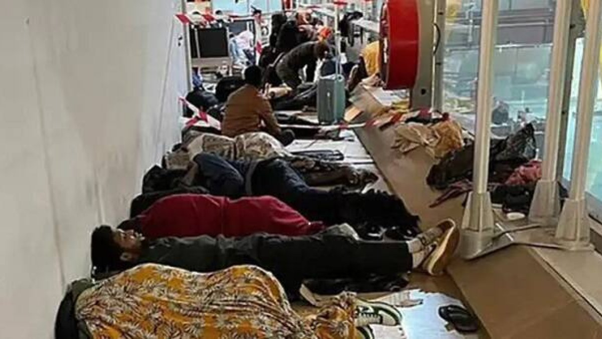 Migrantes durmiendo en el suelo en la zona internacional del aeropuerto de Barajas en febrero