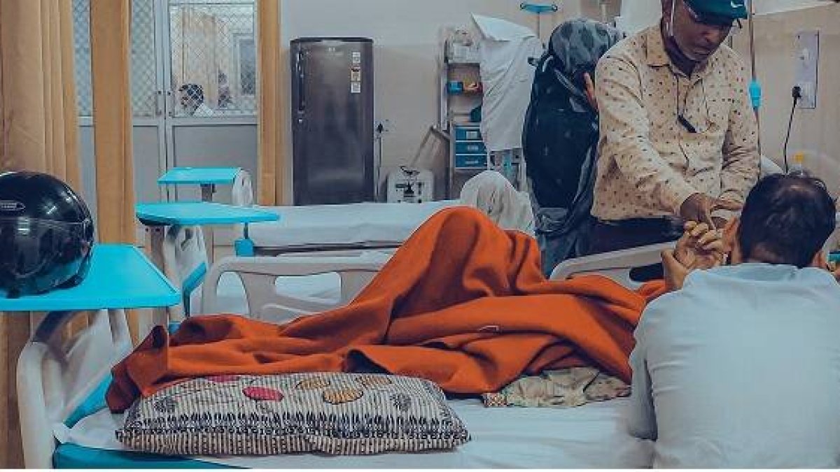 Dos hombres acompañan a un enfermo en la cama, quizá un moribundo - foto de Anirudh en Unsplash