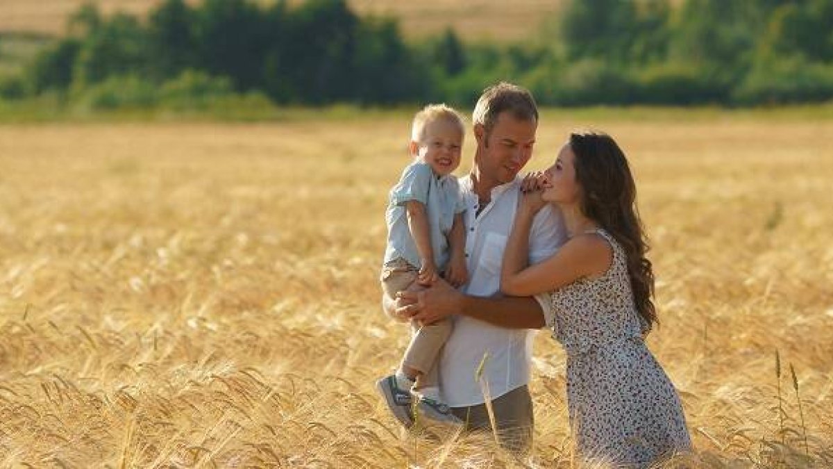 Una familia feliz en un campo dorado... la familia cristiana es una buena noticia para el mundo
