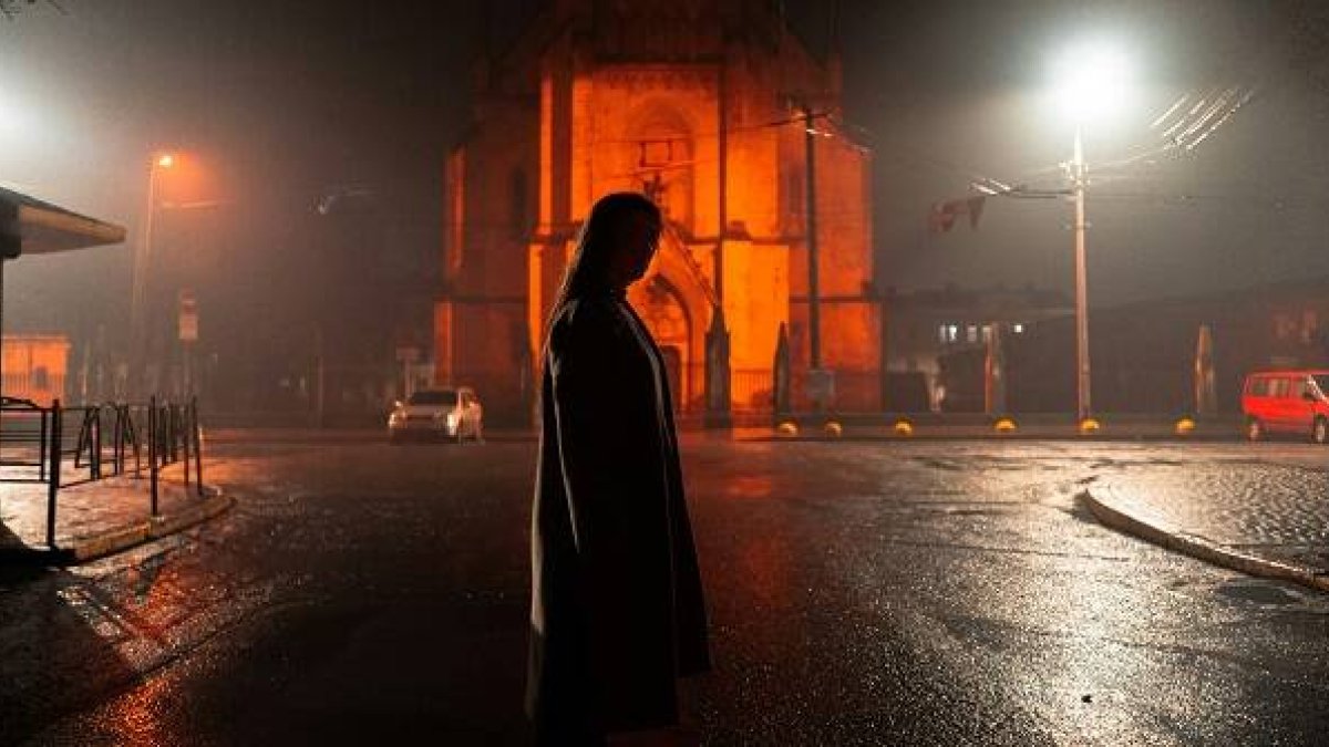 Una mujer sola en la calle de noche, y una iglesia cerrada... foto de Niko Tsviliov para Unsplash