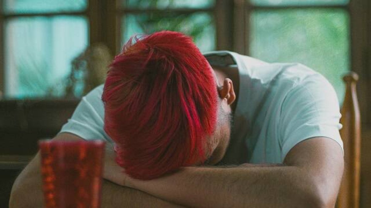 Un joven de pelo rojo, hundido, quizá deprimido... foto por Jose Pena en Unsplash