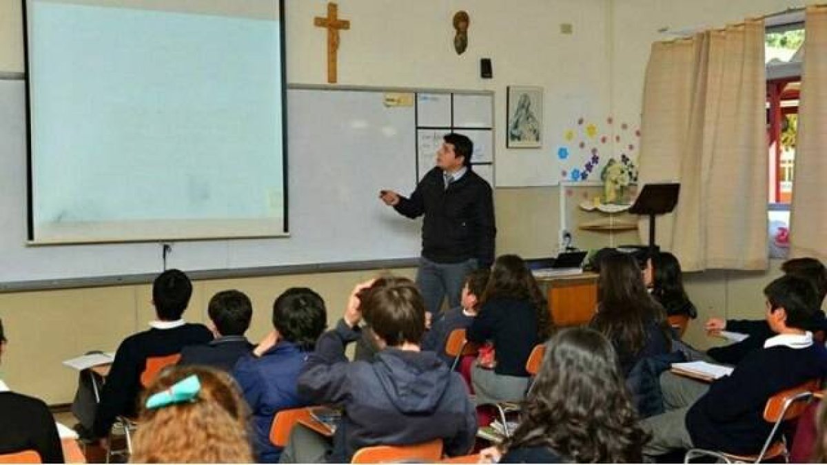 Una clase en una escuela católica, con crucifijo y una imagen de la Virgen