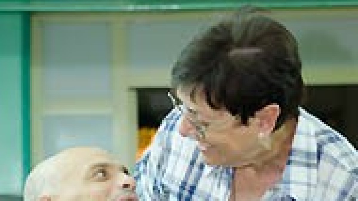 Carmen, con una persona acogida en el Hogar.