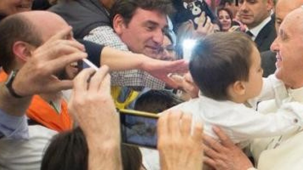 El Papa Francisco toma en brazos al niño de unos cursillistas españoles en el encuentro con esta ya veterana realidad eclesial y evangelizadora