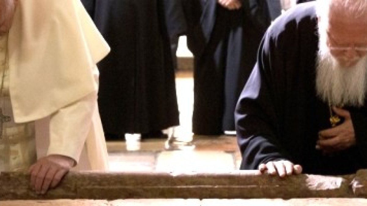 El Papa Francisco y el Patriarca Bartolomé de Constantinopla se arrodillan juntos al entrar al Santo Sepulcro en 2014