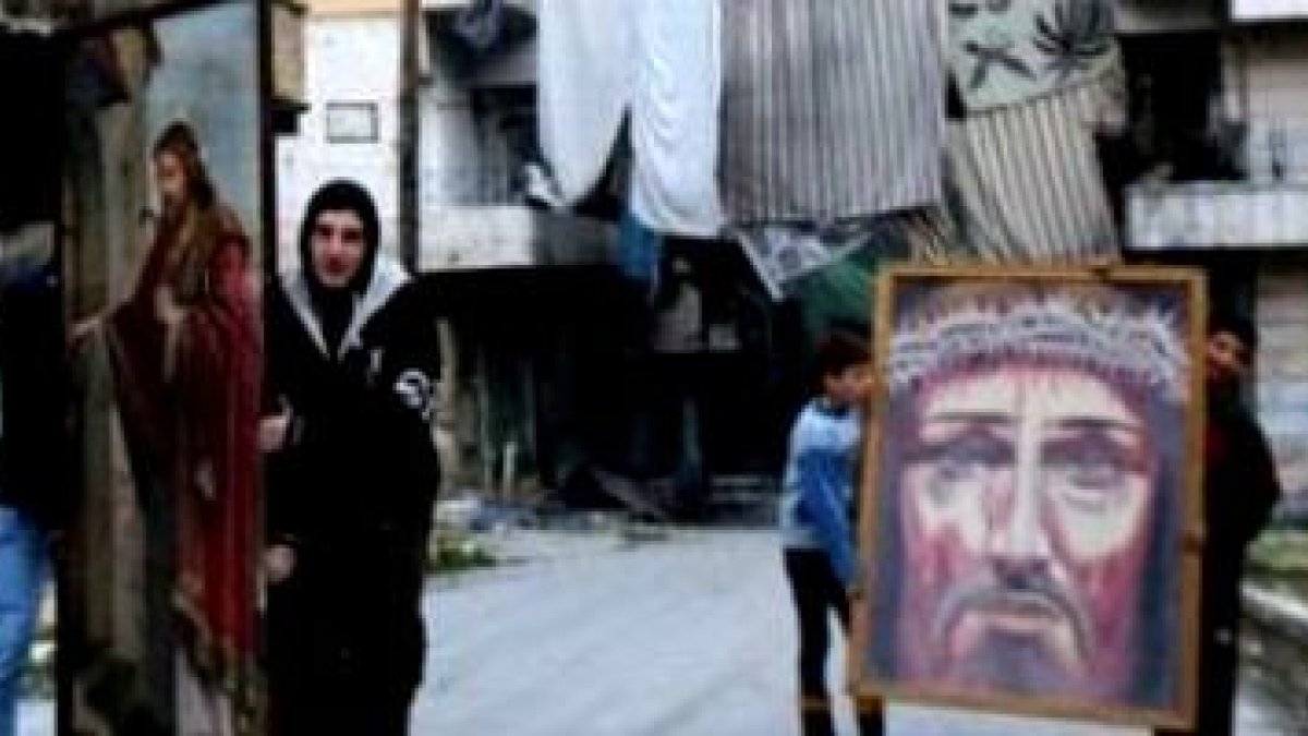 Unos jóvenes cristianos de Alepo trasladan unas imágenes de Cristo, en una foto difundida por AsiaNews