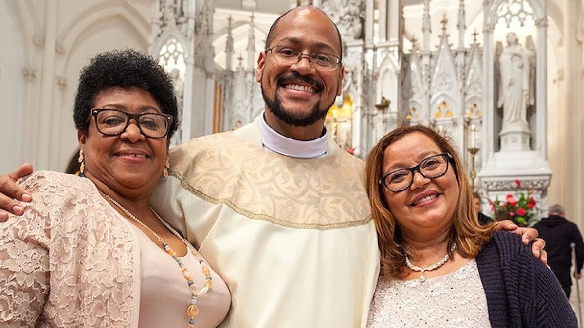 El padre Ángel Miguel abraza a su madre (a su derecha) y a su madrina (a su izquierda) en el día de su ordenación.