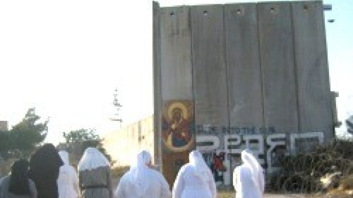 Unas religiosas católicas pasan junto al muro que tiene encajonados a los habitantes de Belén