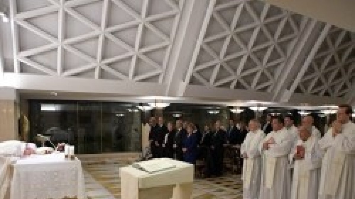 Francisco besa el altar al iniciarse la misa en la Residencia Santa Marta