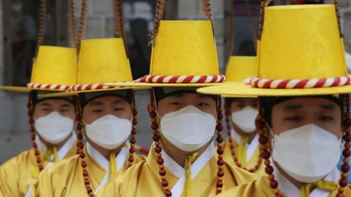 Coreanos con traje típico y mascarillas contra el coronavirus