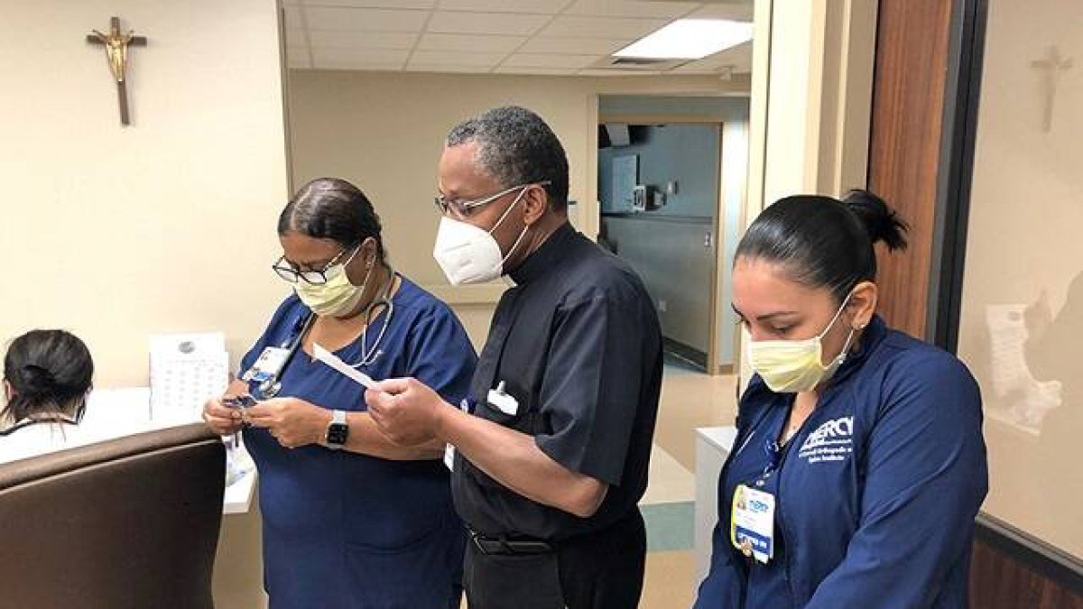 Un capellán reza con unas sanitarias en un hospital de Miami - en todo el mundo la cultura de la vida afronta grandes desafíos