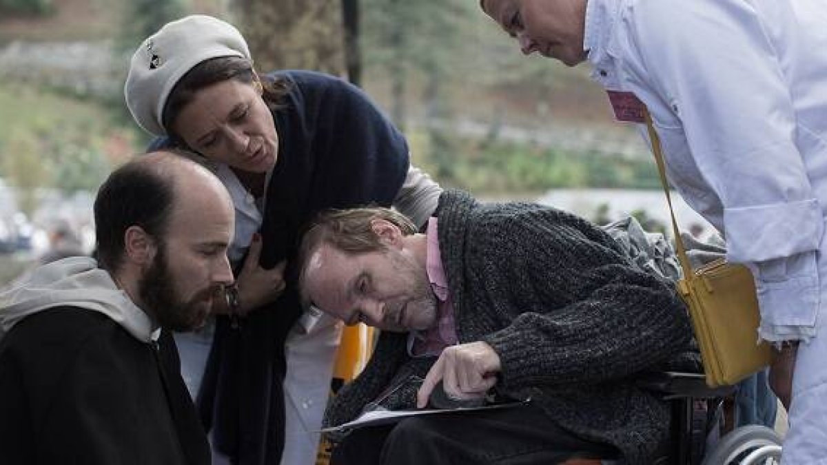 Escena de la película Lourdes, en que unos hospitalarios atienden lo que dice un peregrino enfermo
