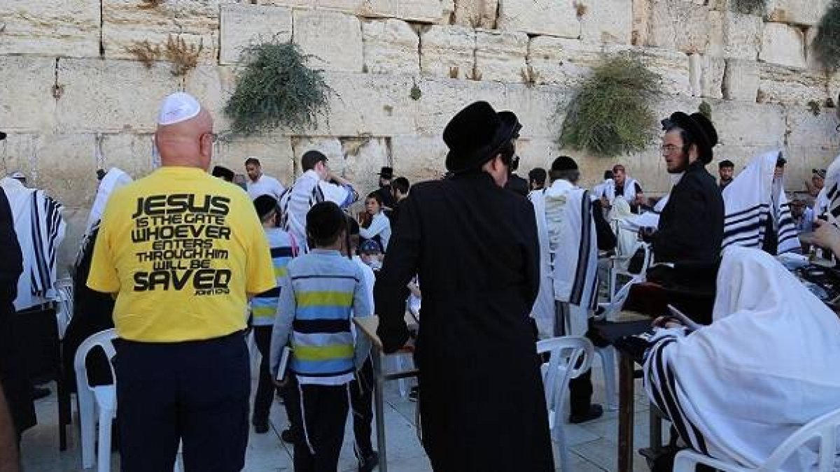 El hombre de la camiseta amarilla lleva un mensaje cristiano, Jesús como puerta a la salvación, en el Muro de las Lamentaciones de Jerusalén