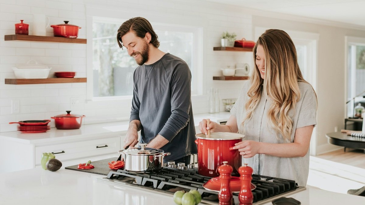 Una pareja cocinando felices.
