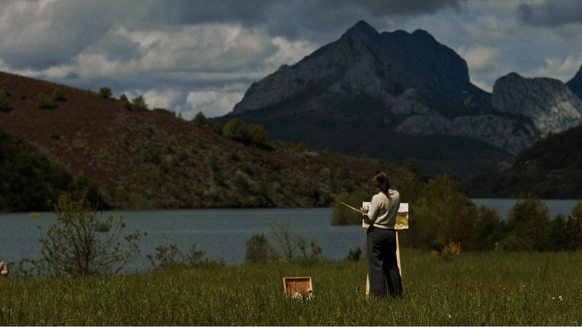 Una joven pinta un lago y montaña en la película Descalzos
