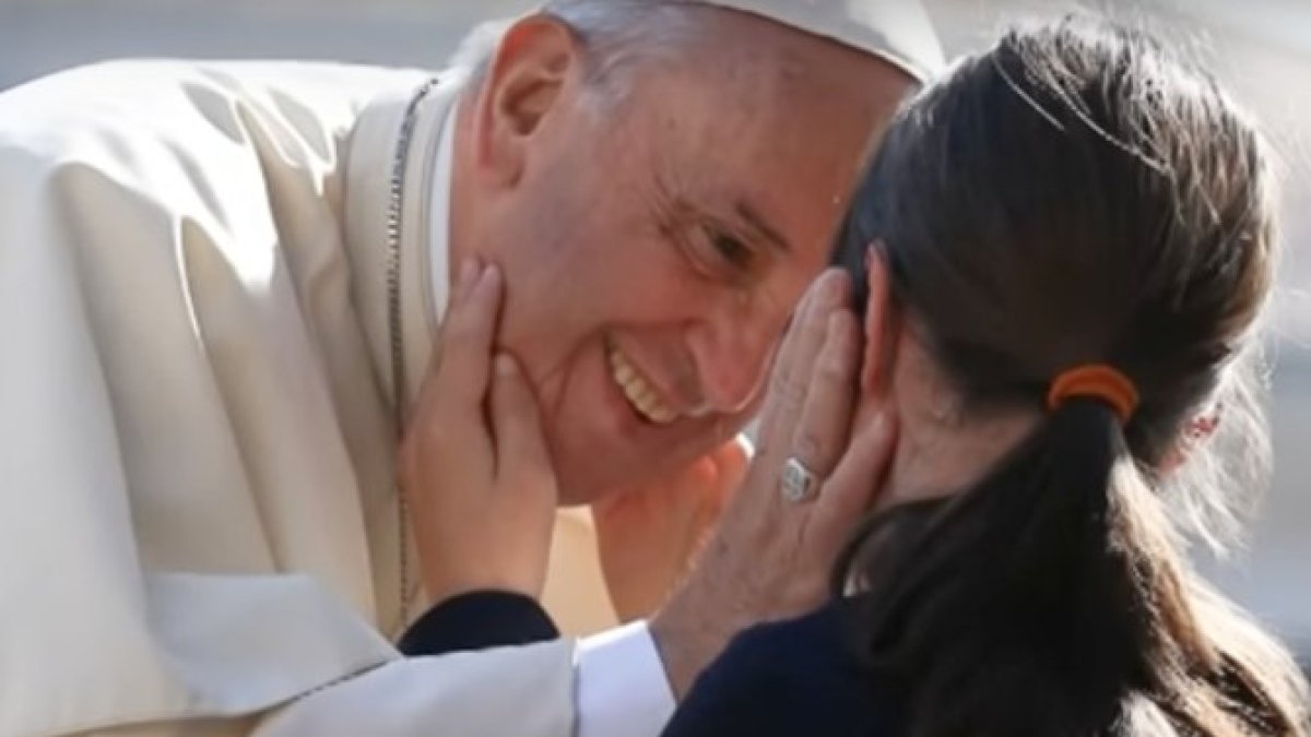 Francisco saluda a una niña ciega que le palpa para identificarle.