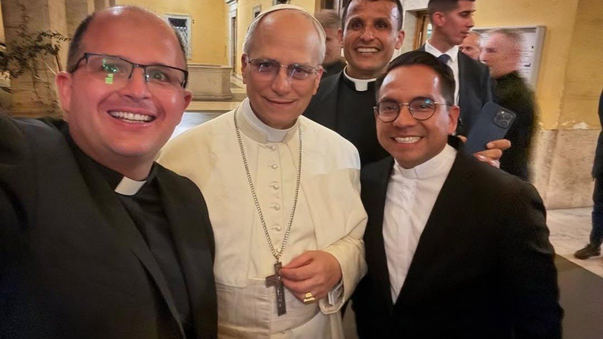 El Papa León XIV, vestido de blanco, con sacerdotes con los que se hizo un selfi en el Vaticano.