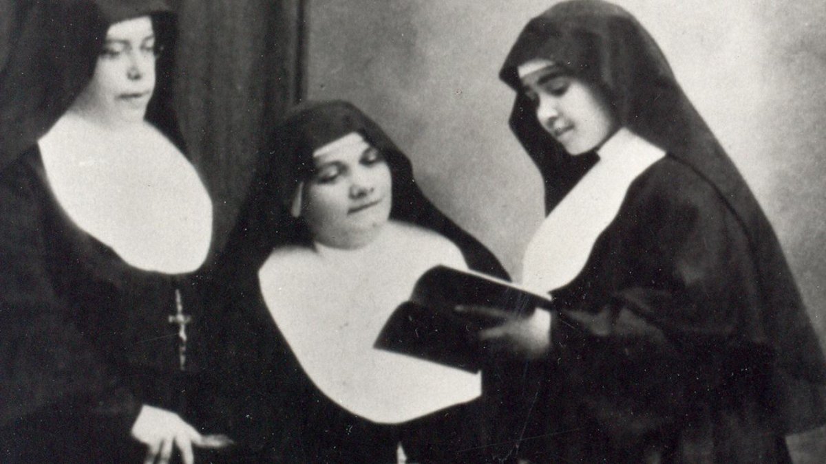 Sor Eusebia Palomino, a la derecha de la foto, lee un libro ante dos de sus compañeras de orden.