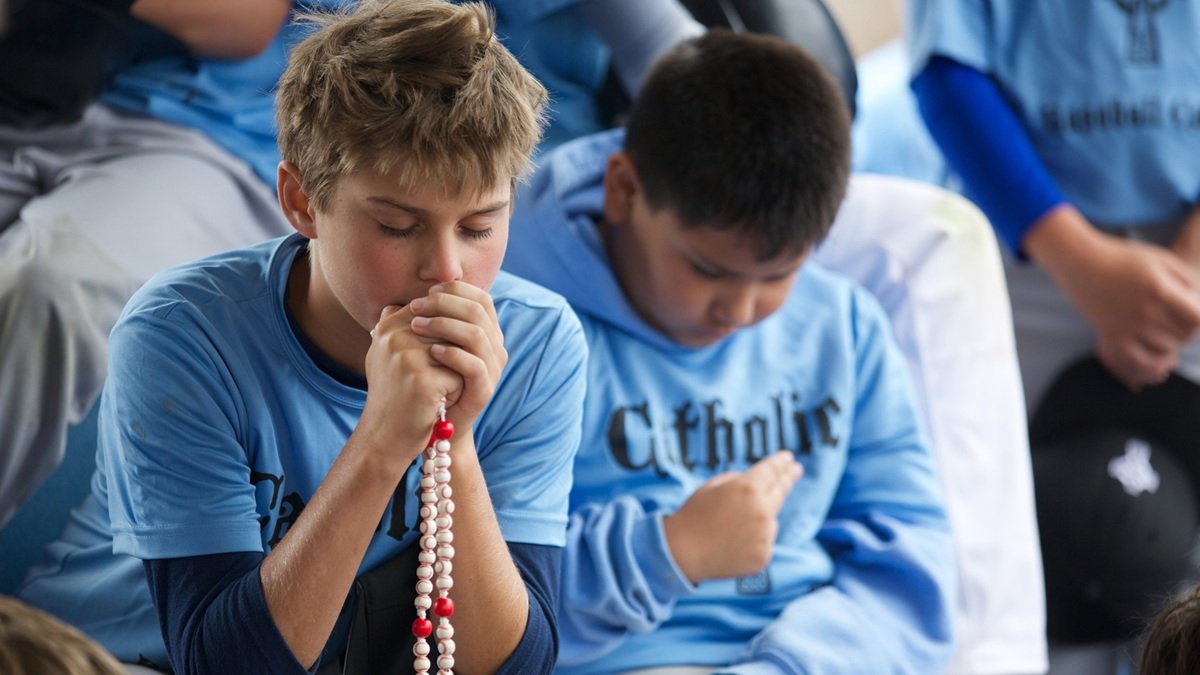 Jóvenes rezan el rosario el 24 de julio durante el Campamento de Béisbol Católico Mike Sweeney.