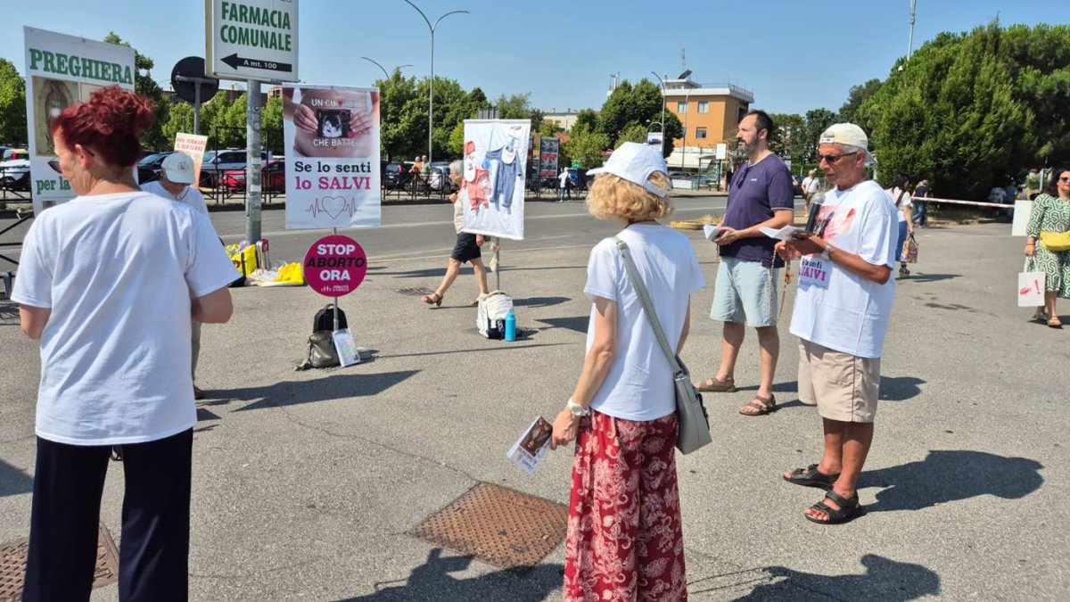 Un grupo de personas rezan el Rosario junto a un hospital en Monza (Lombardía).