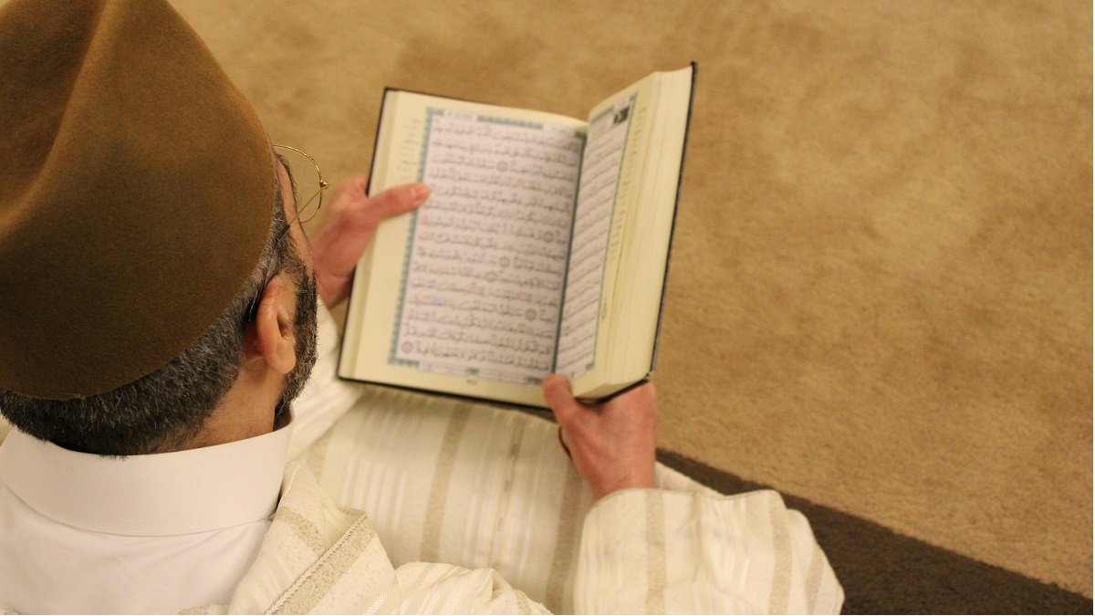 Un hombre reza con el Corán - foto de Rachid Oucharia en Unsplash