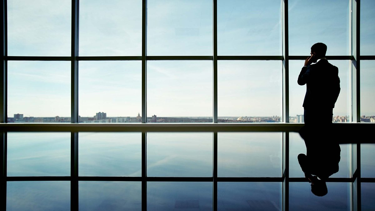Un hombre de negocios mirando por la ventana.