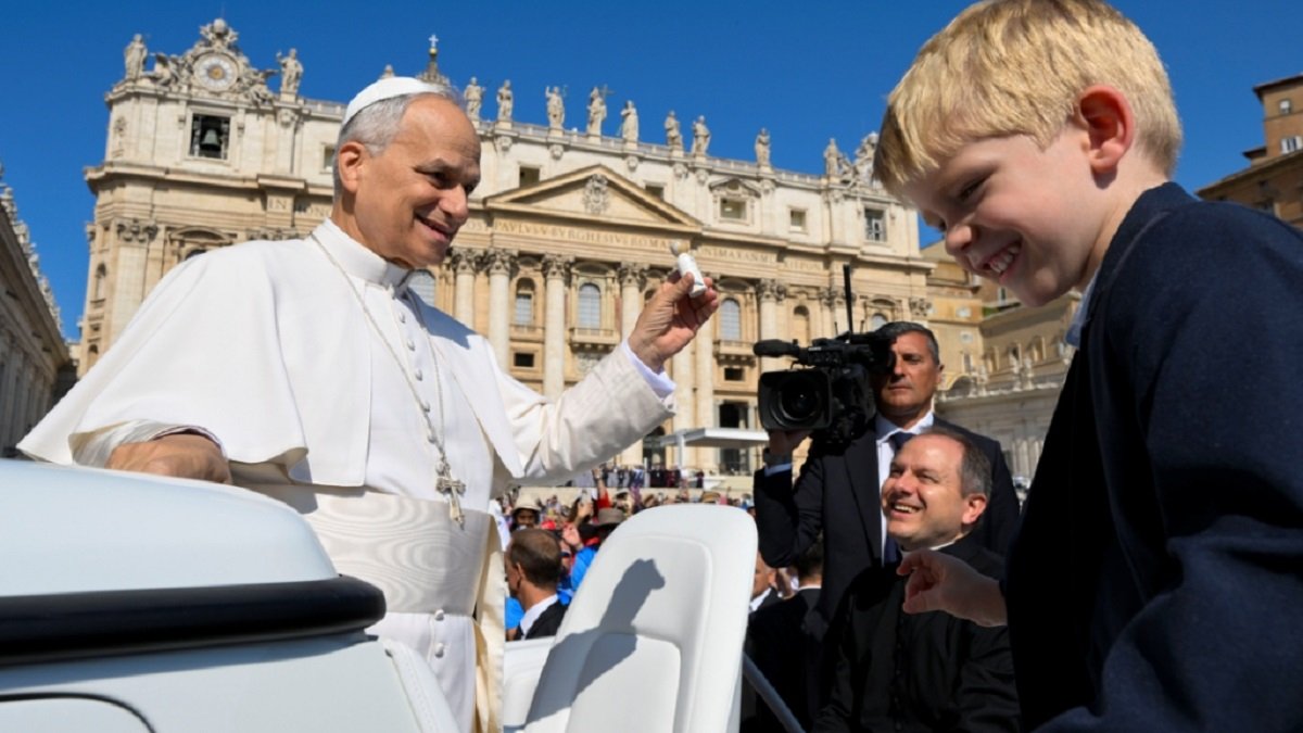 El Papa León XIV en una de las audiencias de los miércoles en la plaza de San Pedro del Vaticano, con un niño y unos cámaras
