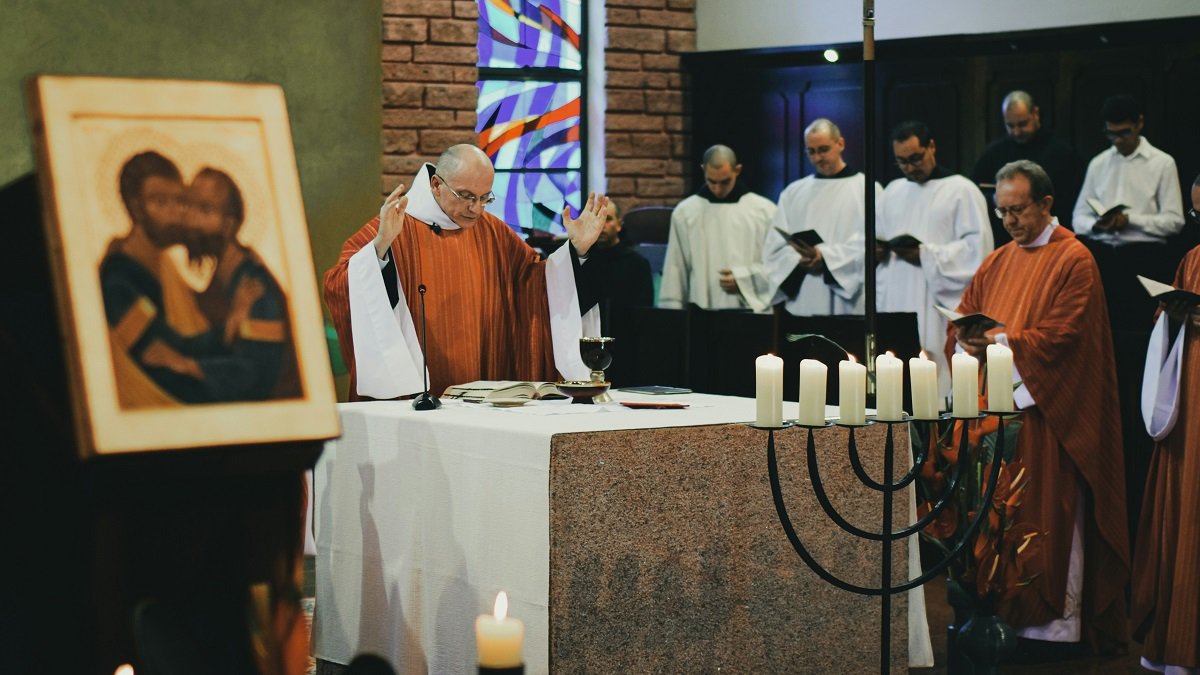 Un sacerdote celebra misa, junto a un icono que representa el beso entre San Pedro y San Pablo, símbolo de fraternidad cristiana y sacerdotal