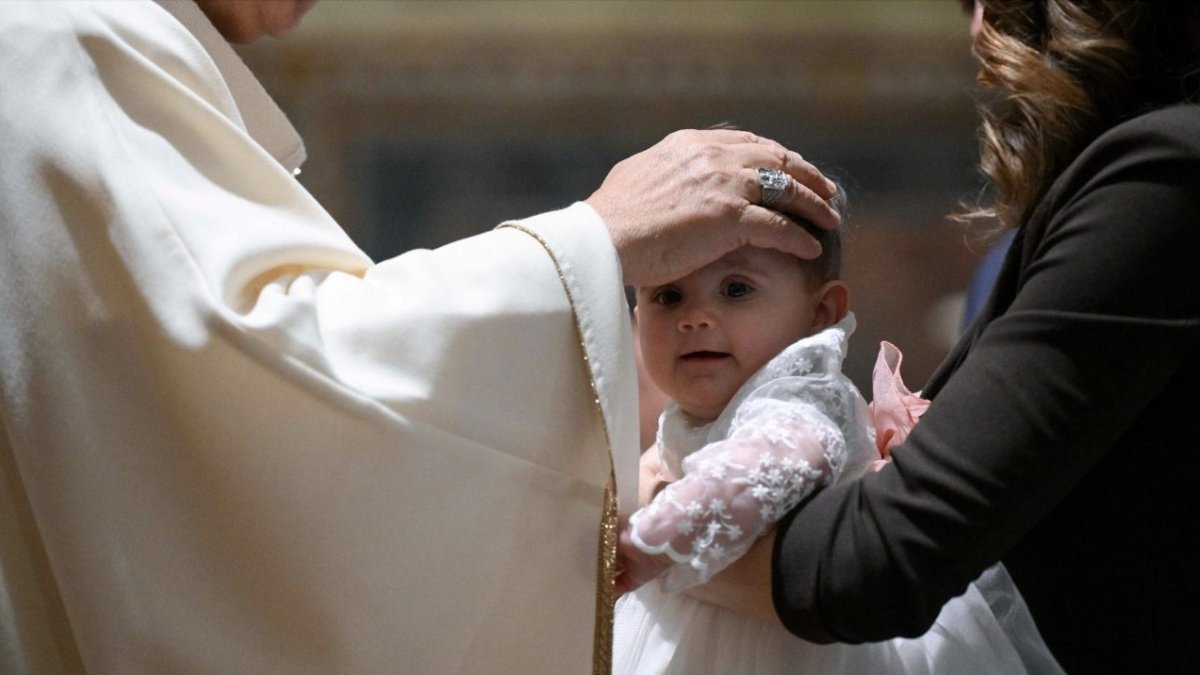 El Papa León impone las manos a un bebé durante la misa en el Vaticano.